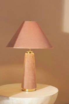 a pink lamp sitting on top of a white table