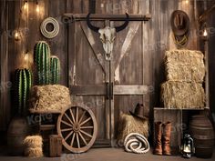 an old western scene with hay, cactus and cow skull on the barn door wall