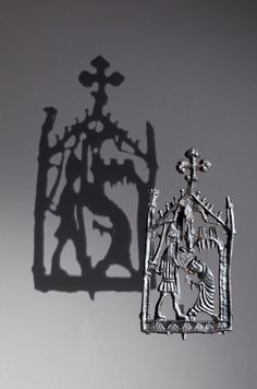 a shadow cast on the side of a wall with an image of a man holding a cross