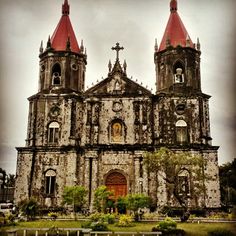 an old church with two towers and red roof tops