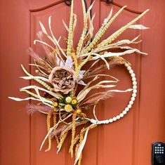 an orange door with a wreath on the front and side of it that is decorated with flowers