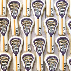 many decorated cookies are arranged in the shape of lacrosse sticks and letters on top of each other