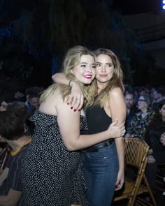 two women hugging each other in front of an audience