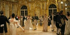 a group of people dressed in formal wear walking around an ornately decorated room with gold and white walls