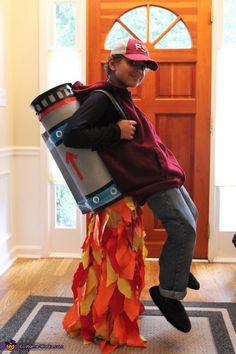 a man in a red shirt and hat is holding a large barrel while sitting on the floor