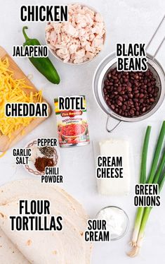 the ingredients to make mexican chicken burritos on a white table with green onions, black beans and cheese