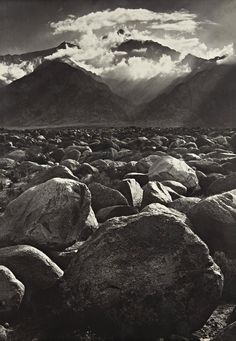 black and white photograph of rocky terrain with mountains in the background