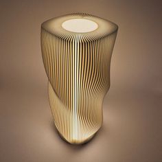 an unusual looking vase with wavy lines on the side and a circular light at the top