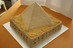 a cake made to look like an egyptian pyramid with writing on the bottom and sides