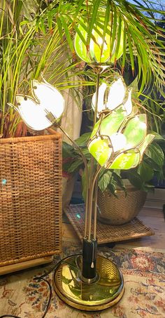 a lamp that is on top of a table next to a basket and potted plant