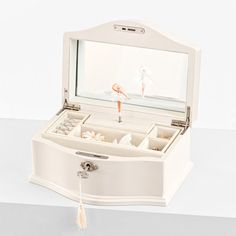 an open white jewelry box sitting on top of a table