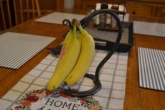 two bananas sitting on top of a table next to a heater and napkins