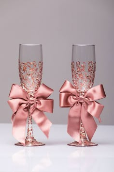 two wine glasses with pink bows on them