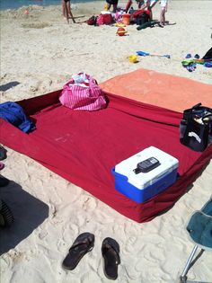 an image of a beach towel and flip flops on the sand with text reading use a fitted sheet to keep sand off when at the beach