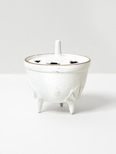 a white ceramic bowl with an animal design on the bottom and two holes in the middle