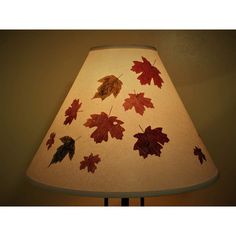 a lamp that has some leaves on it and is turned on to look like fall