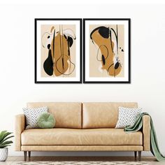 two abstract paintings hang on the wall above a couch in front of a potted plant