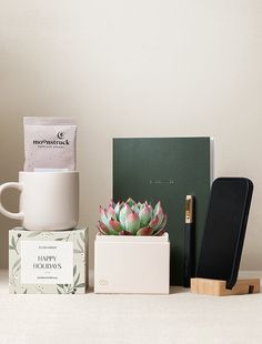 an assortment of items sitting on top of a table next to a phone and notebook