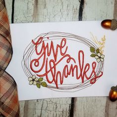 a piece of paper with the words give thanks written in red on it next to some autumn decorations