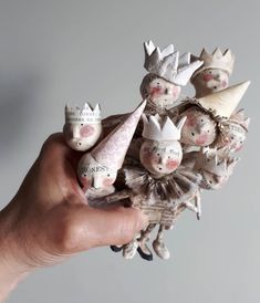 a hand holding a bunch of small figurines