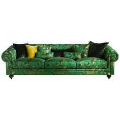 a green couch with many pillows on it