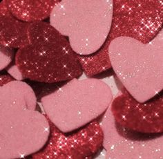 pink and red heart shaped confetti sitting on top of each other