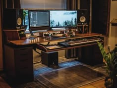 a computer desk with two monitors and keyboards on it, in front of a window