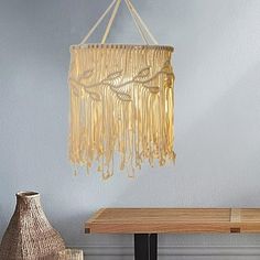 a wooden table with a vase on it and a chandelier hanging from the ceiling