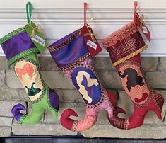 three colorful christmas stockings hanging from a fireplace