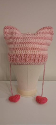 a crocheted pink hat on top of a white mannequin head