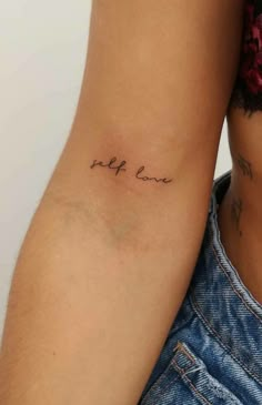 a woman's arm with the word love tattooed on it