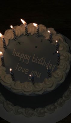 a birthday cake with lit candles on it that says happy birthday love you in the middle