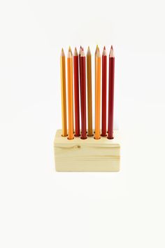 six colored pencils in a wooden holder