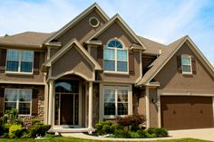 a large house with lots of windows and grass in front of the garage door is shown