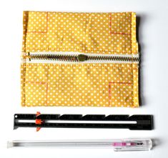 sewing supplies laid out on top of each other, including rulers and zippers