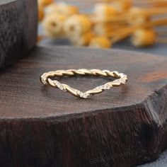 a gold ring with diamonds on top of a wooden table next to some other items