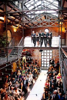 a group of people that are standing in the middle of a room with some stairs