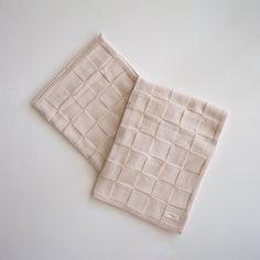 two pieces of cloth sitting next to each other on top of a white countertop