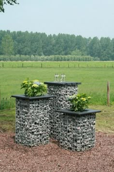 three planters sitting on top of each other in front of a field