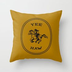 a yellow pillow with an image of a man on a horse in the center and yee haw