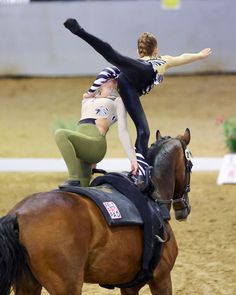 a woman riding on the back of a brown horse while standing on its hind legs