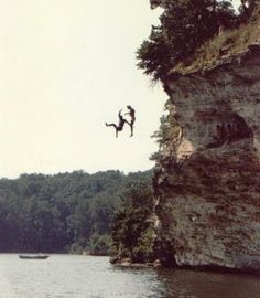 a person jumping off a cliff into the water