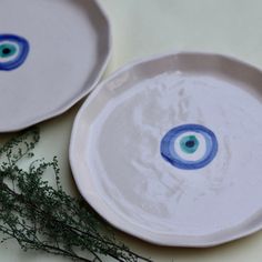 two white plates with blue eyes on them