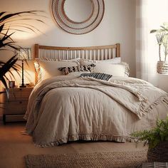 a bedroom with a large bed and plants in the corner