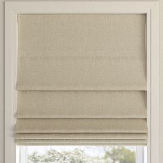 an open window with a beige roman blind