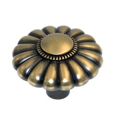 an antique brass finish knob on a white background