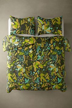 an image of a bed with green and yellow comforter set on top of it