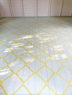 an empty garage with yellow lines painted on the floor and white tiles in the background