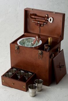 an old suitcase is filled with cups and a hot tub in the bottom compartment,