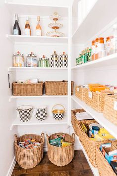 an organized pantry with baskets, food and condiments on the shelves in white shelving